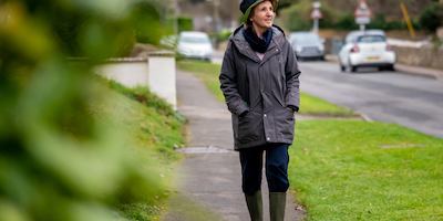 an older woman walking along a residential street
