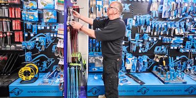 Male worker in a hardware shop tidying stock on the shelves