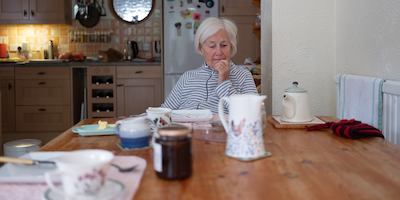 Older woman sitting by a table in her home