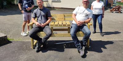 Two people sitting on an age-friendly bench