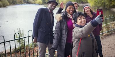 Older group of adults taking a selfie in front of a lake