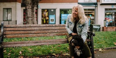older woman sitting down with a dog
