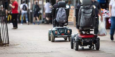 Older people on a mobility scooter on high street