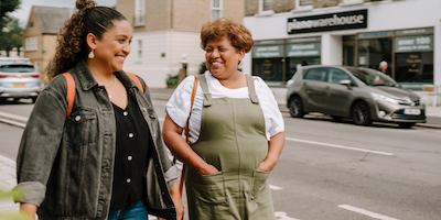 Younger and older woman walking together