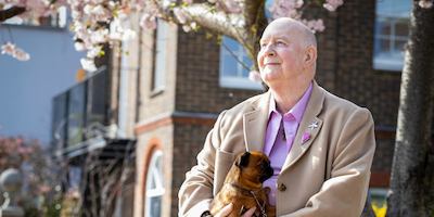 older man with his dog outside