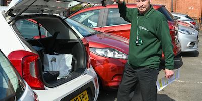 Older worker standing by car