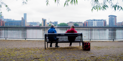 Two BAME people sitting on a bench