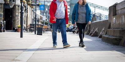 older man and woman walking down the street