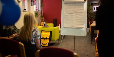 a group of people talking around a whiteboard
