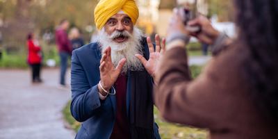 Woman taking a photo of an older man