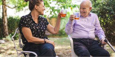 Older man and woman sitting together drinking tea