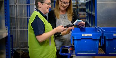 Two women examine products in a warehouse