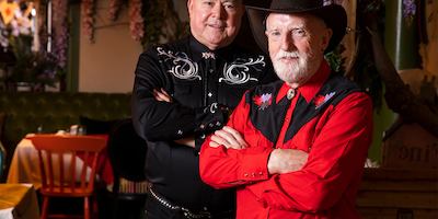 Patrick and David in their line dancing outfits smiling at the camera