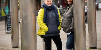 Two older women leaning against columns outside