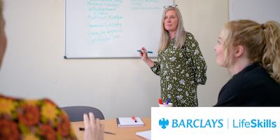 An older workers leading a meeting with a whiteboard