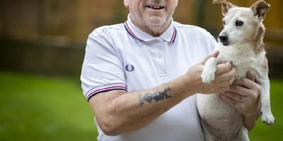 an older man holding his dog