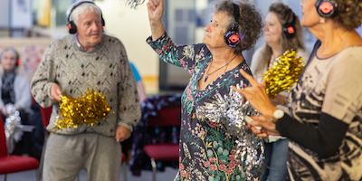 People dancing at silent disco with tinsel pompoms