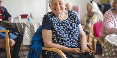 woman in a community hall smiling at the camera
