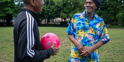 Older man playing football with his son