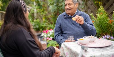 Older people outside having snacks