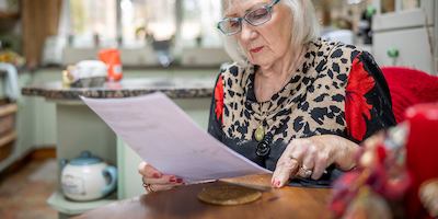 Older woman in home looking at papers