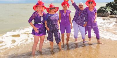Five people on the beachThe winning photo of North Norfolk’s Age Positive Photography Competition. ’Red Hat Ladies’ by Sally Redgrave.