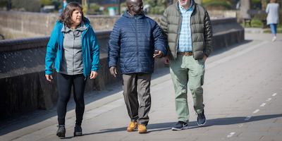 A group of older people walking by a canal