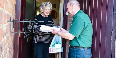 Older-man-delivering-shopping-to-an-older-woman