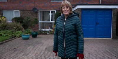 Older-woman-standing-outside-house