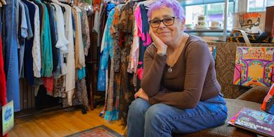 Woman in clothing shop smiling at camera