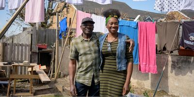 An older man and his daughter hang clothes on a washing line