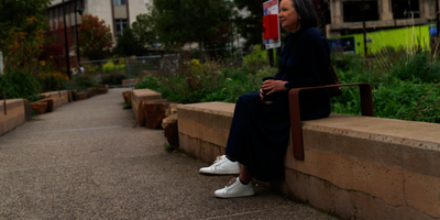 An older woman sitting on a bench