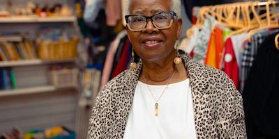 Older woman in charity shop with glasses