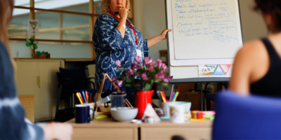 An older woman writing on a board