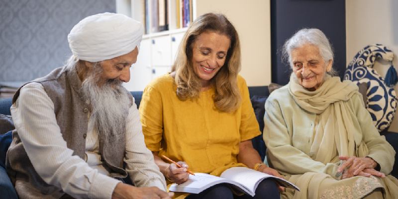 three older people sitting down and reading