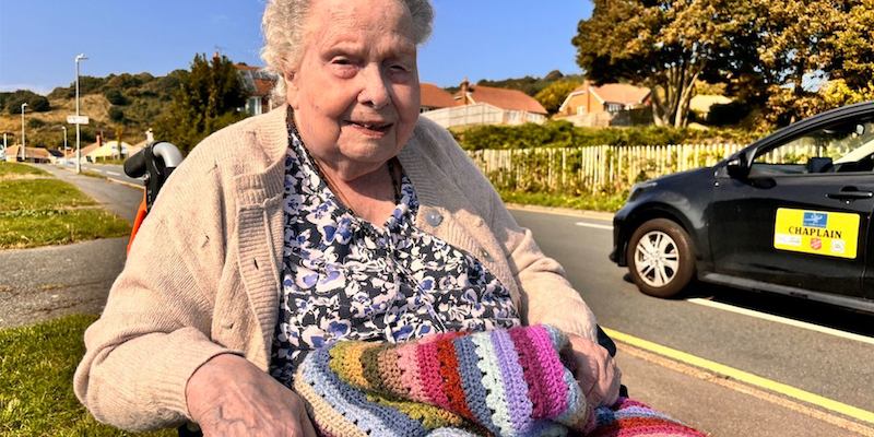 An-older-woman-in-a-wheelchair-smiling-outdoors