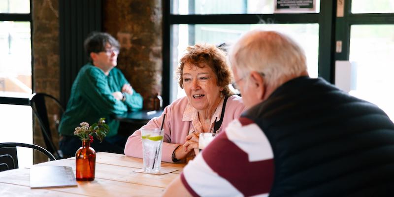 Man and woman chat in a pub