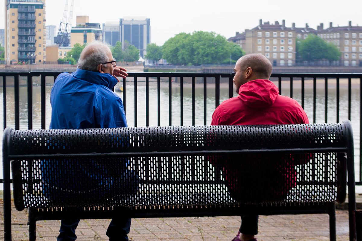 Two men seated on a bench by the Thames