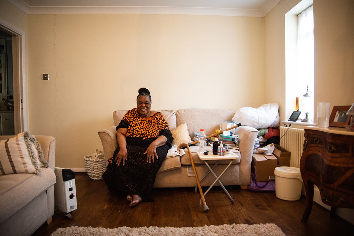 Woman seated on sofa at home in living room.