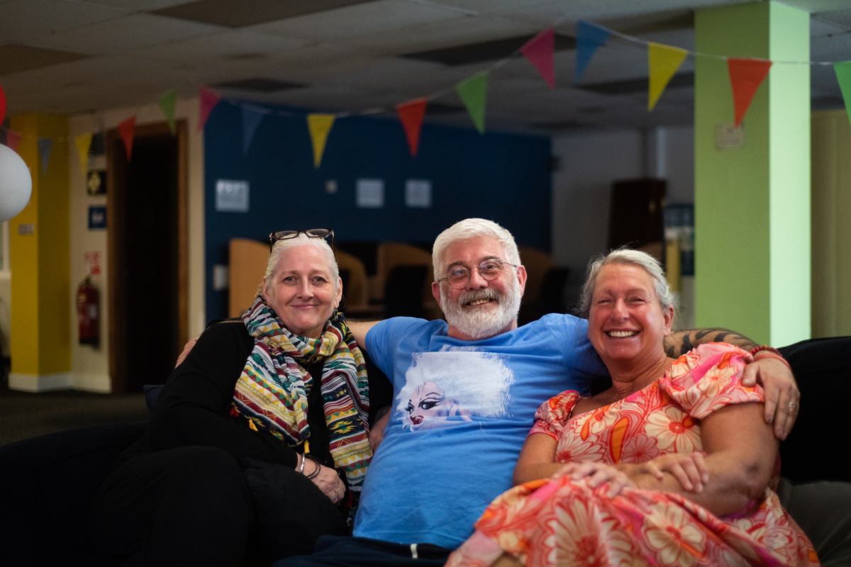 Tony with two other carers sitting down and smiling
