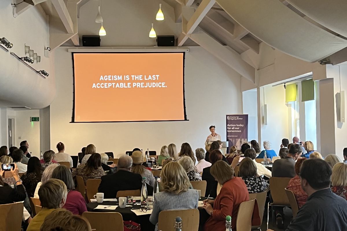 A busy conference with the speaker talking about ageism