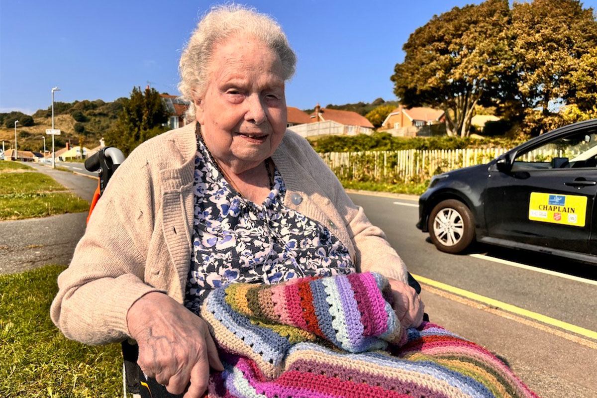 An-older-woman-in-a-wheelchair-smiling-outdoors