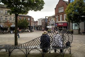 Two women sitting on a bench in Macclesfield