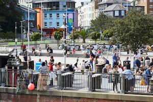 Group of people enjoying the sun by a bridge