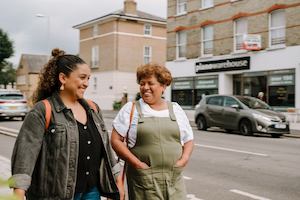 Younger and older woman walking together