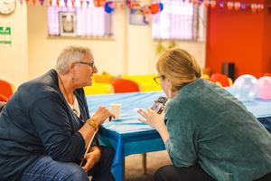 Two women talking and looking at a phone