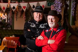 Patrick and David in their line dancing outfits smiling at the camera
