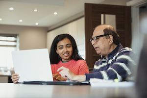 An older man and younger woman working together