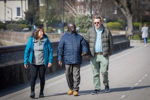 A group of older people walking by a canal