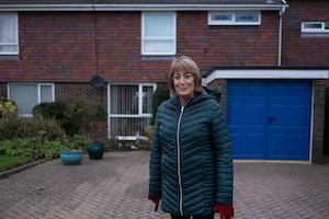 Older-woman-standing-outside-house